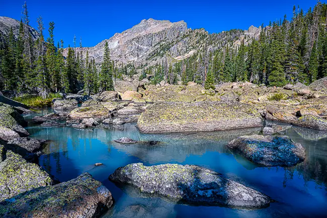 https://ywguiding.com/Images/650/650%20webp/Lake-Haiyaha-blue-water-Rocky-Mountain-National-Park-Tours.webp